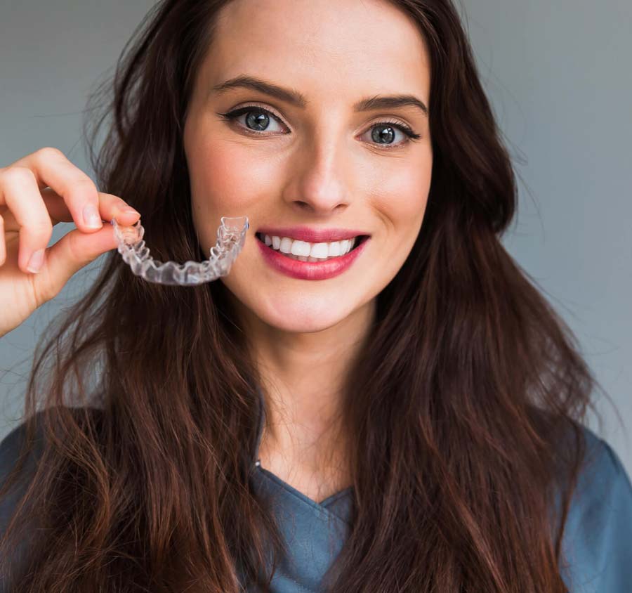 Brunette holding clear aligner