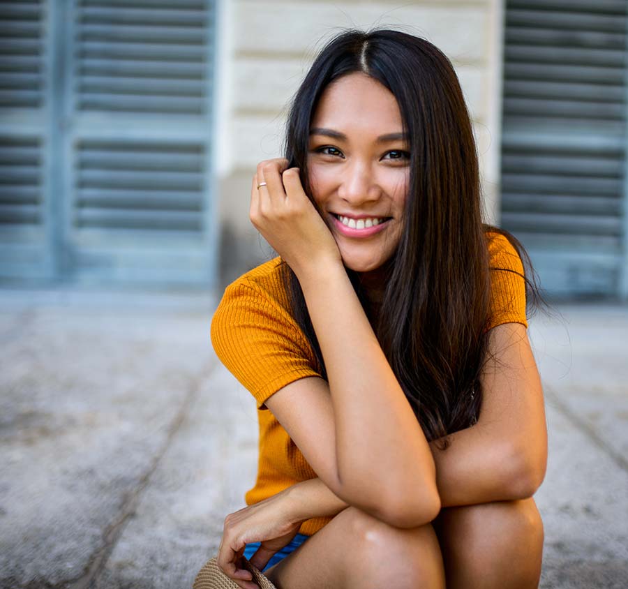 Asian female sitting and smiling