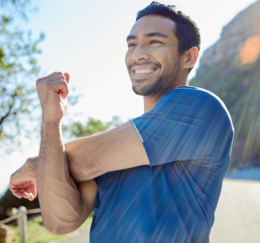 Hispanic male stretching and smiling