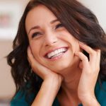 Woman smiling while touching face